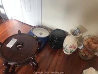Photo showing five carved wooden vase/plant stands in dark wood, a hand-painted Japanese dish, a light-colored painted floral vase, dark blue circular stand, and a glass container with dried decorative items.