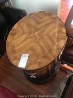 Top view of the oval table showing detailed grain pattern and gloss finish with auction tag.