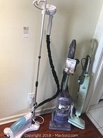 Photo showing all three appliances together: Shark Navigator Lift-Away vacuum, Tobi steamer, Bissell steam mop.