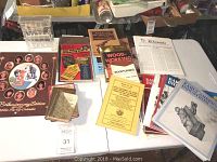 Overview of the lot showing the calendar, books, magazines, coin sorter all arranged on a table.