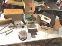 Full view of all items on table: plane, cutters, radar detector in box, timer, stones and hair dryer case
