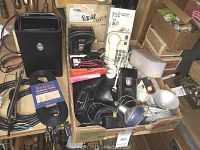 Photo showing multiple Simpson testing devices and accessory cords in cardboard box and surrounding storage area.