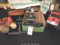 Two vintage leather baseball mitts, one brown and one marked Johnny O'Dea Model 32, along with a baseball ball, two toy remote control vehicles (a black Turbo drag racer and a red Ford 4x4 truck), and a pull-up bar.