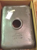 Underside of the Kohler cast iron sink showing the cast Kohler branding and size markings, placed in original packaging box.