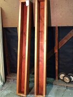 Two rectangular wooden planters stained redwood color, shown upright and side by side, displaying their depth and size.