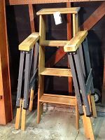 Photo of a four-foot wooden step ladder with armrests and two expandable wood and metal saw horses partially folded, showing their wood tops and metal legs.
