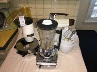 Wide view showing Sunbeam Mixmaster mixer, Hamilton Beach blender, ToastMaster waffle maker on kitchen surface