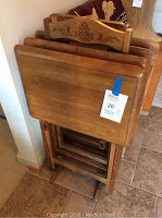 Four wooden TV trays stacked on wooden stand with carved pineapple decoration