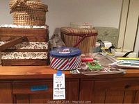 Photo of multiple sewing boxes and containers, showcasing the assortment of sewing supplies included in the lot such as baskets, tins, and thread spools.