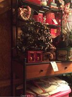Full view of metal and wooden shelving unit loaded with holiday decorations on upper shelves.