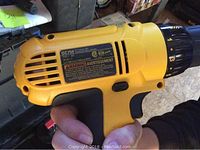 Handheld side view of yellow/black DeWalt drill body showing model DC759 label