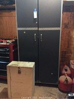 Grey metal cabinet with small wooden box in front, showing overall items