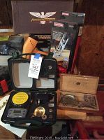 Lot photo showing digital precision scale in black case next to vintage American scale in wooden box and a Craftsman drill guide box in background.