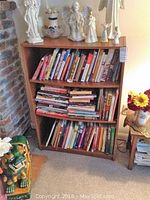 Bookcase filled with books, showing wear, photo taken to show condition and appearance of bookcase with contents.