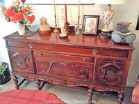 Front elevation view of entire sideboard showing carved details, drawer, cabinet doors and hardware