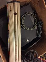 Box containing Yamaha subwoofer, Monster power bar, and audio cables coiled on top
