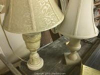 Overall view of the pair of stone table lamps with fabric shades showing size difference and style