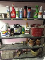 Metal shelf unit with cleaning chemicals, garden chemicals, tools, pots, and miscellaneous items arranged across multiple shelves.