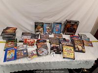 Full view of the table with approximately 34 PC games in cases and boxes arranged in rows