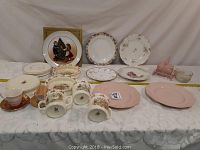 Full view of lot with assorted plates and teacups arranged on table.
