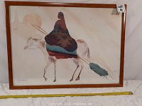 Framed watercolor painting showing an Inuit figure riding a horse, signed by artist in the bottom corner.
