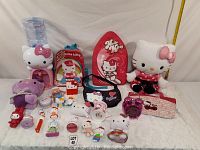 Photo showing a variety of Hello Kitty and Miss Kitty toys and collectibles on a white surface with a white background.