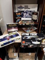 Photo of Star Trek and Star Wars items including models, books, games, and space-themed kits on a shelf