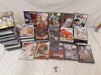 Photo showing a collection of manga and anime DVDs, including series such as Death Note, Tenchi, Master Keaton, Slayers, and Cardcaptor Sakura, spread out on a white surface.