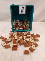Photo of Mahjong tiles scattered with a teal plastic container labeled LOT 60.