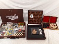 Full lot overview showing Deluxe Chess set box with bags of chess pieces and accessories, wooden checkers board, and small boxes with chess pieces.