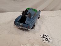 Rear view of blue toy car showing mounted guns on hood and trunk, and detailed back