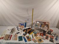 Full overview of aviation-related supplies including model airplane parts, decals, wiring, adhesives, and tools spread out on a table.