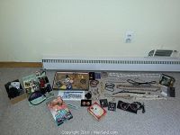 Full assortment of costume jewelry laid out on carpet including necklaces, bracelets, earrings, hair barrettes, hair ties, bows, pins and brooches.