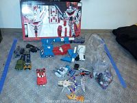 Overview of lot: boxed Jetfire, Ultra Magnus cab, Swoop, loose parts and weapons