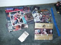 Overview of magazines, loose cards, and sealed SP Authentic box on carpet