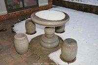 Front view of circular table and four stools on snowy patio