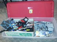 Plastic bin with assembled Lego Dragster, TIE Fighter wings, assorted Lego pieces in boxes