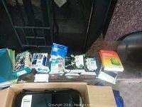 Various printer ink cartridges aligned with other small office supplies and electronics