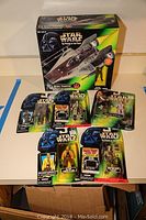 Photo shows all boxed items laid out including A Wing Fighter box and seven packaged figures lying flat.