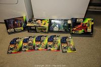 Photo of all Star Wars collectible figures and sets arranged on floor, showcasing boxed and blister-packaged items including Cloud Car vehicle, Jabba the Hutt dancers, and others.
