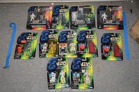 Full lot of 10 Star Wars action figures sealed in original packaging from 1996 and 1997, laid out on the floor for visual inventory.