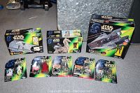Photo showing the full set of Star Wars collectibles including boxed vehicles and action figures on cards.