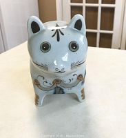 Front view of the handpainted signed Mexican pottery cat figure showing glossy light blue glaze with facial details and decoration.