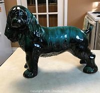 Front side view of large dark green Blue Mountain Pottery Cocker Spaniel figurine placed on kitchen counter