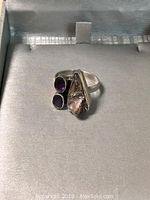 Front view of sterling silver ring with two amethyst stones and one mother of pearl setting showing the size and detail.