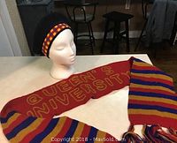 Full view of Queens University knit scarf laid out with tam hat on mannequin head