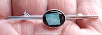Top view of the sterling silver bar pin showing the square fire opal chip on black background in the center oval setting.