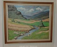 Framed landscape painting showing a stream, hills, and fields under a partly cloudy sky.