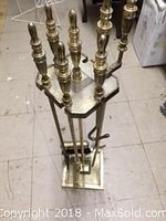 Brass 5-piece fireplace tool set in brass stand on a tiled floor.