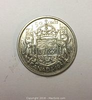 Reverse side of the 1954 Canadian silver 50 cent coin showing the Canadian coat of arms, denomination, and year.
